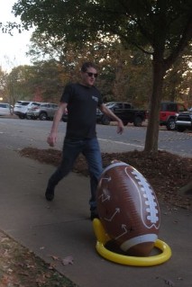 Dr. Greg Colson kicking football at Harvest event